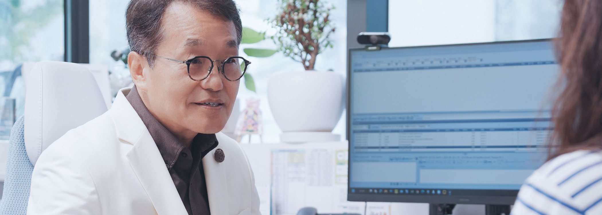 민병현 대표원장이 진료실에서 모니터를 보며 상담하는 모습